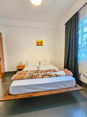 a bed with a wooden frame in a bedroom at Fly Africa Village 2 in Arusha