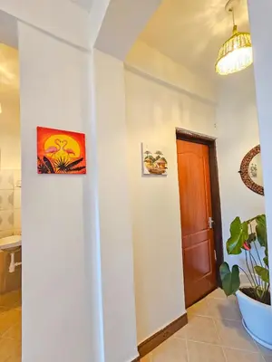 a hallway with a door and a potted plant at Fly Africa Village 2 in Arusha