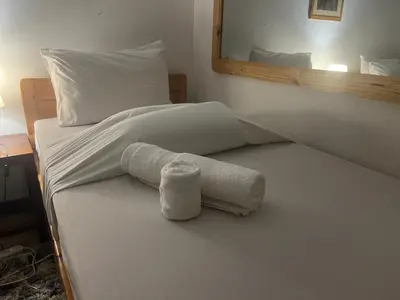a bed with a rolled up towel on it at JDs Home in Arusha