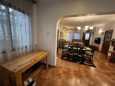 a dining room and living room with a table and chairs at JDs Home in Arusha