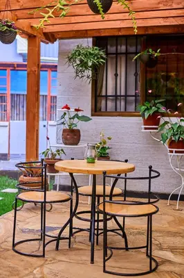 a patio with a table and chairs and potted plants at Lavish Luxury Homes in Tengeru