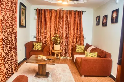 a living room with a couch and a table at Lavish Luxury Homes in Tengeru