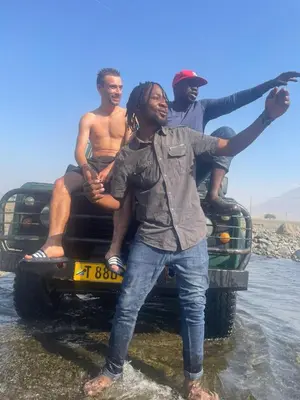a group of three men sitting on the back of a truck at Bethlehem home in Arusha