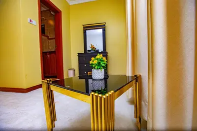 a glass table with a vase of flowers on it at Divine Royal Residences in Arusha