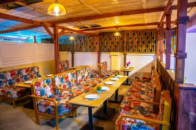 a restaurant with long tables and chairs with plates on them at Divine Royal Residences in Arusha
