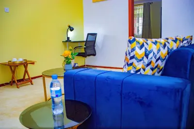 a blue couch in a living room with a water bottle at Divine Royal Residences in Arusha