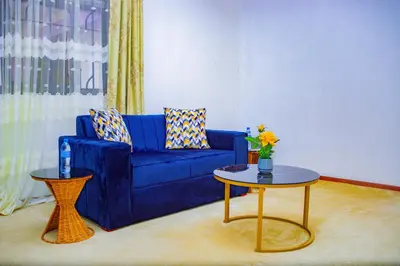a living room with a blue couch and a table at Divine Royal Residences in Arusha