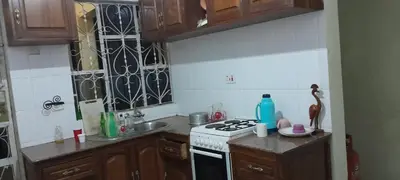 a kitchen with wooden cabinets and a stove top oven at December apartment in Sokon