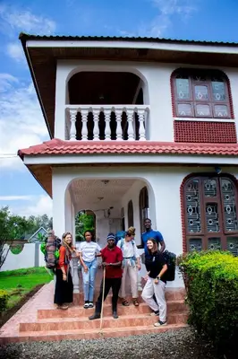 a group of people standing in front of a house at Meru Villa Arusha in Olmotoni
