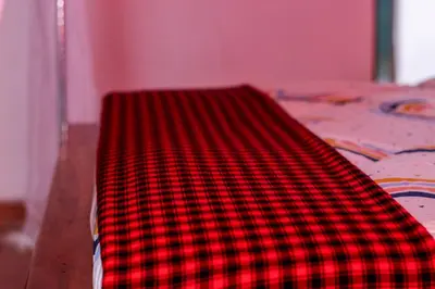 a red and black blanket sitting on top of a bed at Meru Villa Arusha in Olmotoni