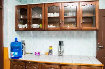 a kitchen counter top with wooden cabinets and utensils at Meru Villa Arusha in Olmotoni