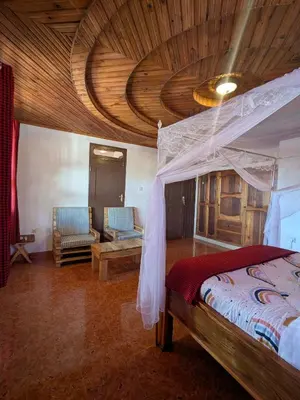 a bedroom with a bed with a wooden ceiling at Meru Villa Arusha in Olmotoni