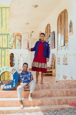 a woman standing on the stairs next to a man at Meru Villa Arusha in Olmotoni