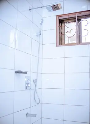 a bathroom with a shower and a window at Tembo Homestay in Arusha