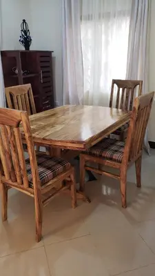 a wooden table and two chairs and a table and a table and chairs at Tembo Homestay in Arusha