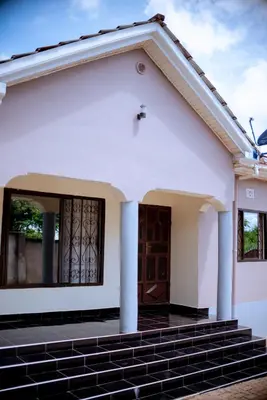 a white house with stairs in front of it at Tembo Homestay in Arusha