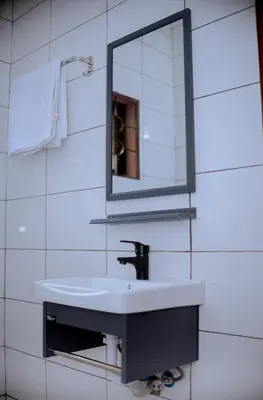 a bathroom with a white sink and a mirror at Tembo Homestay in Arusha