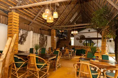 a dining room with wooden tables and chairs at Rafiki Backpackers & Guesthouse in Moshi