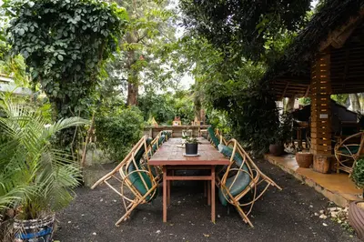 a wooden table and chairs in a garden at Rafiki Backpackers & Guesthouse in Moshi