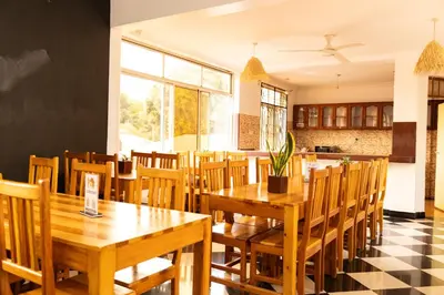 a dining room with wooden tables and chairs at Rafiki Backpackers & Guesthouse in Moshi