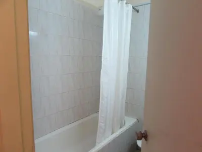 a bathroom with a tub and a shower curtain at Equator Hotel in Arusha