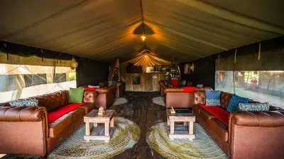 a living room with couches and tables in a tent at Africa Safari South Serengeti Ndutu Camping in Sinoni