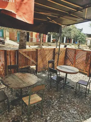 two tables and chairs under an umbrella on a patio at Last fantasy ndoto ya mwisho in Arusha