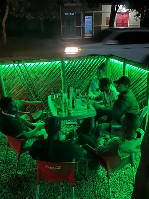 a group of people sitting around a table at night at Last fantasy ndoto ya mwisho in Arusha