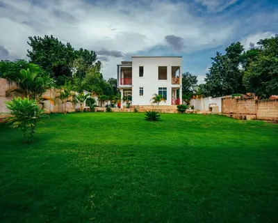 a house in a yard with a green lawn at Shanti Apartments in Uru