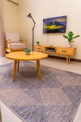 a living room with a coffee table and a tv at Timeless Escape in Arusha