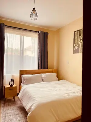 a bedroom with a white bed and a window at Timeless Escape in Arusha