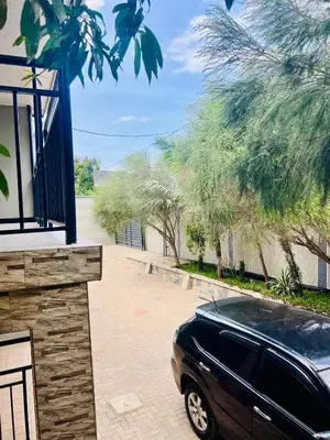 a black car parked in a driveway next to a building at Sunset Inn Lodge in Arusha
