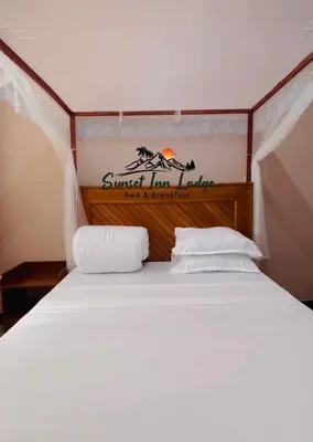 a bedroom with a bed with a sign on it at Sunset Inn Lodge in Arusha