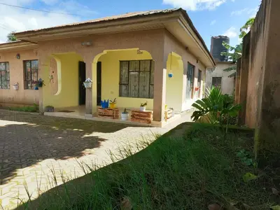 a small house with yellow paint on it at Sofa So Good Backpackers' Nest in Arusha