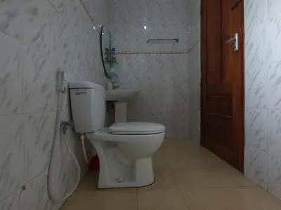 a bathroom with a toilet and a sink at Sofa So Good Backpackers' Nest in Arusha