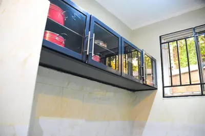 a kitchen with black cabinets and a window at chamber 206 in Arusha