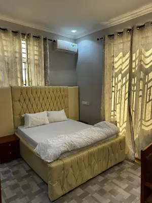 a large bed in a room with curtains at chamber 206 in Arusha