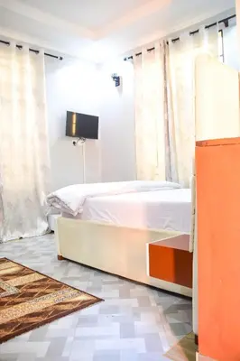 a bedroom with a bed and a tv on the wall at chamber 206 in Arusha