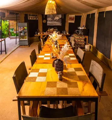 a long wooden table with chairs in a room at Kibo View Farm Lodge in Shiri