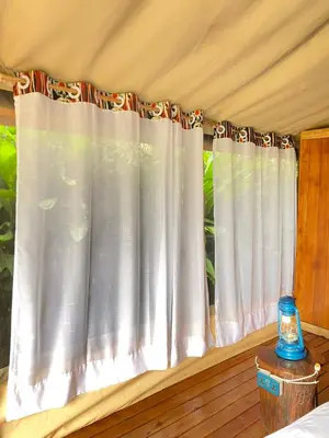 a window with white curtains in a bedroom at Kibo View Farm Lodge in Shiri
