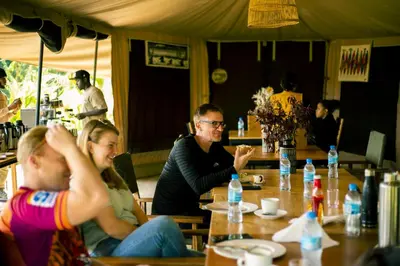 a group of people sitting at a table in a restaurant at Kibo View Farm Lodge in Shiri