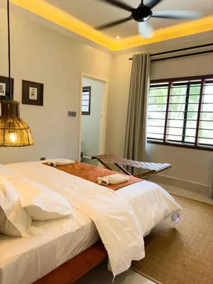 a bedroom with a large bed and a ceiling fan at The Green House in Arusha