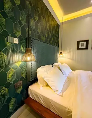 a bedroom with a bed and a green wall at The Green House in Arusha