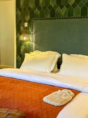 a pair of beds with a towel on the floor at The Green House in Arusha