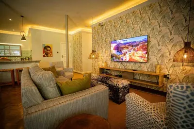 a living room with a tv hanging above a fireplace at The Green House in Arusha