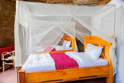 a bedroom with two beds with a mosquito net at Kili View Maasai Lodge in Longido