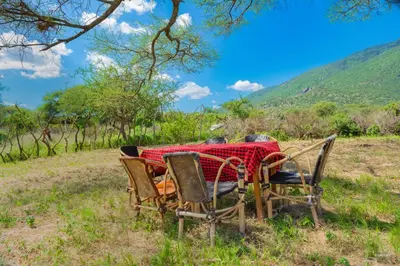 a table with chairs and a red table cloth at Kili View Maasai Lodge in Longido