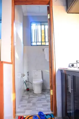 a bathroom with a toilet and a window at chamber 206 in Arusha
