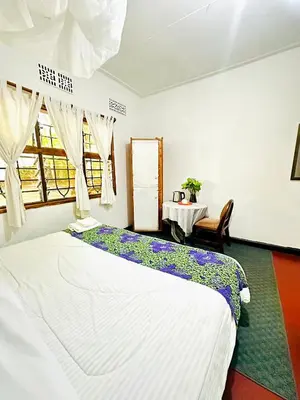 a bedroom with a large bed and a table at Ethiopian restaurant and lodge in Arusha