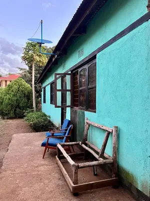 two blue chairs sitting outside of a blue building at Shambani Homestay in Moshi